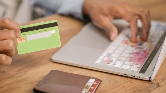 Hombre pagando con una tarjeta de credito un servicio virtual como Google Gemini Spark