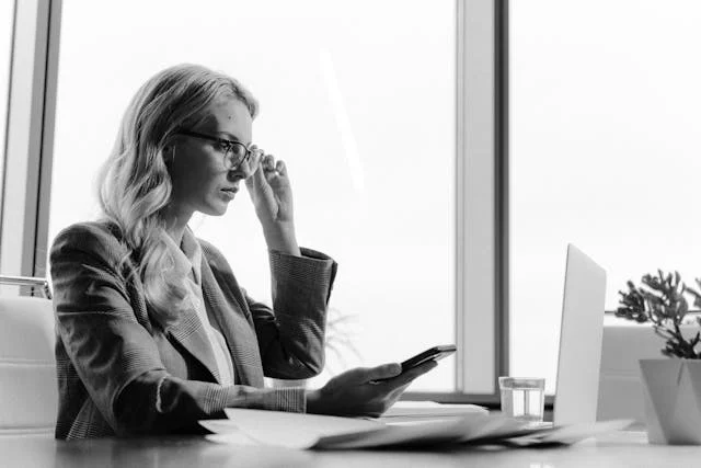 Mujer inteligente usando lentes frente a laptop donde está trabajando