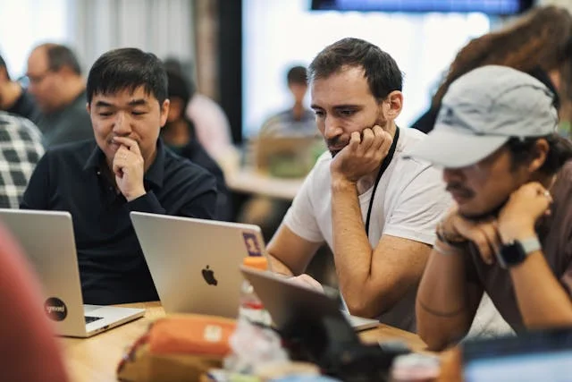 Tres hombres empresarios trabajando en sus computadores que usan inteligencia artificial
