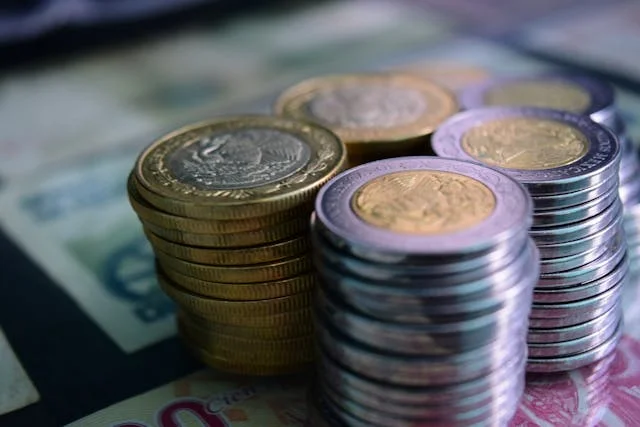 Monedas apiladas junto a billetes
